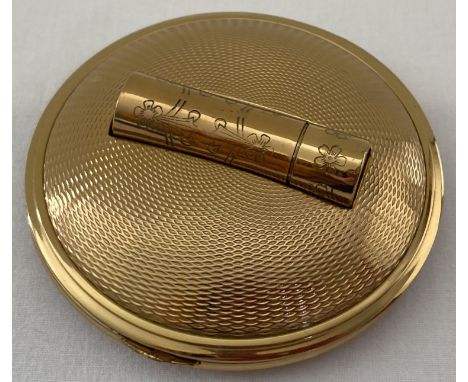 A vintage goldtone compact with lipstick holder by Melissa with carry pouch. Engine turned decoration throughout case with fl