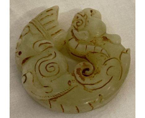 A Chinese Jade carved roundel depicting figural detail to one end &amp; mythical creature to the other. Carved detail to both
