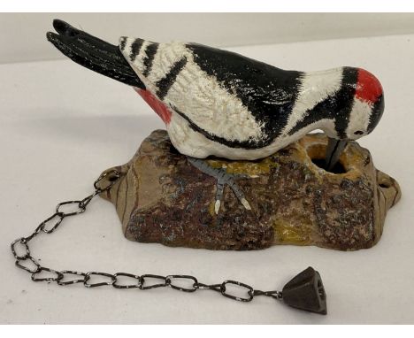 A painted cast metal door knocker in the shape of a woodpecker with fixing holes. Complete with chain pull. Total height (wit