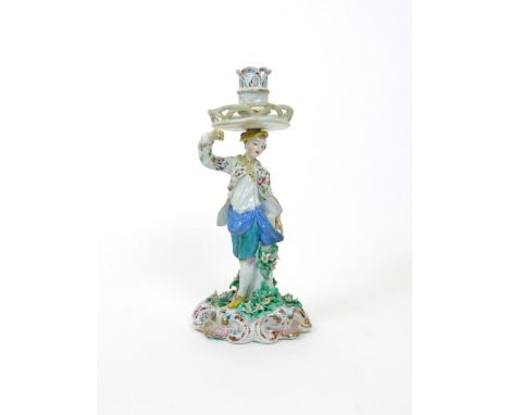 A rare Bow candlestick figure of a dancer, c.1760, his right arm raised and head turned to the left, standing on a scrolled b