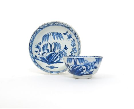 A Bow blue and white teabowl and saucer, c.1760, painted with willow and peony issuing from large leaves, the interior rim wi