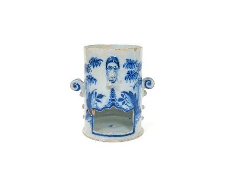 An English delftware food warmer base, c.1760-70, of cylindrical form with a shaped opening beneath a moulded mask, painted i