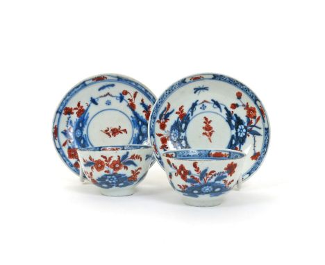 A pair of Cozzi teabowls and saucers, c.1760-70, painted in underglaze blue and overglaze red with Oriental flower sprays wit