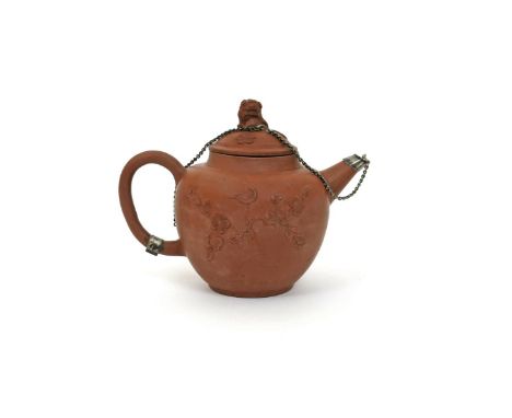 An English redware teapot and cover, 18th century, the globular stoneware body applied with a bird perched atop flowering bra