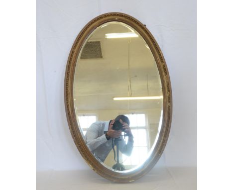 An oval bevelled wall mirror in an egg and dart and beaded gilt frame.  Est £15-30