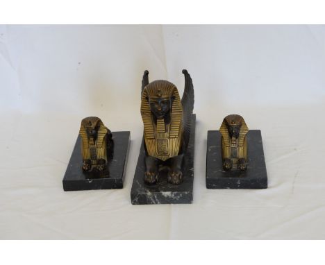 A bronze winged sphinx on a black and white marble veined base together with two smaller ditto.  Est £70-100