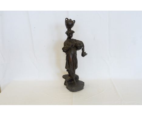 A cast bronze figure of a young lady carrying a twin handled urn on her head with a further urn under her left arm and to her