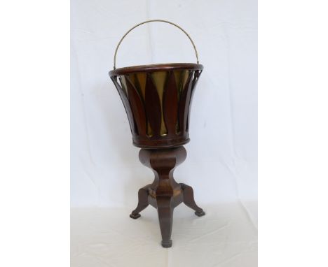 A Victorian mahogany wine cooler with brass swing handle centre surrounded by a pierced border, octagonal tapering stem and t