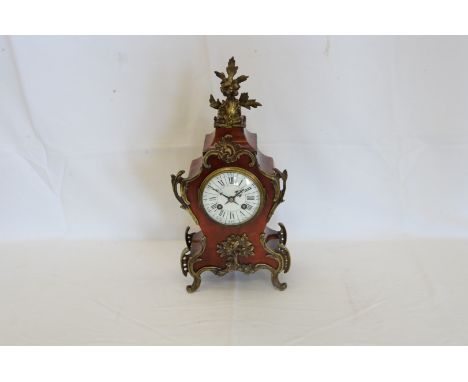 An early 20th century French ormolu and tortoise shell cased mantel clock with stylised floral and leaf finial, the enamelled