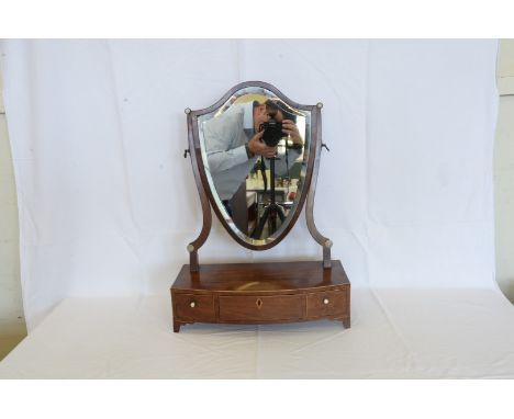 A 19th century mahogany and boxwood strung dressing table mirror with shield shaped mirror plate, on a bow front base with th