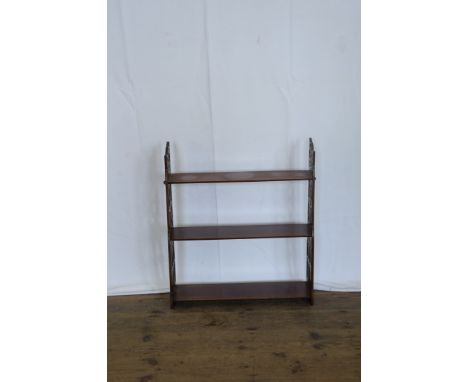 A 19th century mahogany wall shelf with pierced fretwork ends and three graduated shelves.  24ins wide.  Est £40-60