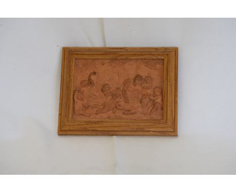 An 18th century or earlier terracotta panel depicting cherubs in a landscape with a goat.  6 by 4¼ins in a light oak frame.  