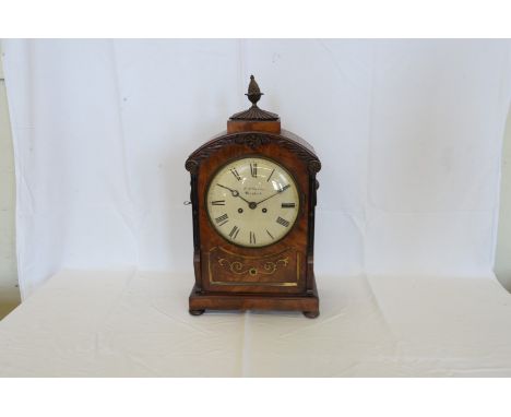 A 19th century mahogany cased bracket clock with pineapple form finial above a gadrooned plinth and domed acanthus leaf carve