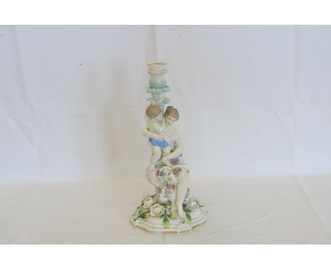 A Dresden porcelain candlestick, the central column in the form of a seated lady holding a young boy on a flower head decorat