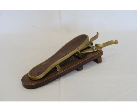 A brass mounted mahogany shoe/boot remover with push-button mechanism.  Est £30-50