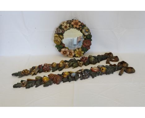 A circular wall mirror with carved floral decorated border. 11ins diameter together with a pair of matching garlands with pla