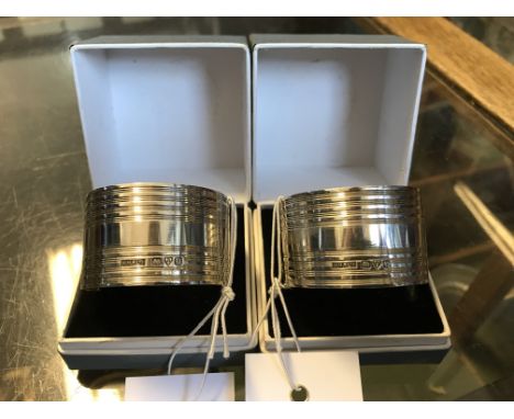 A pair of George VI silver napkin rings with engine turned banded exteriors.  Chester 1945.  Makers W.H.F. Ltd in original pr