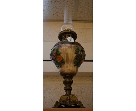 A Rococo Revival brass mounted table lamp with ceramic reservoir decorated in relief with flowers on mottled grey ground