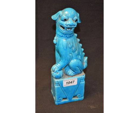 A Chinese Republican turquoise monochrome model, of a temple lion, he sits with one paw on an 'embroidered' reticulated ball,