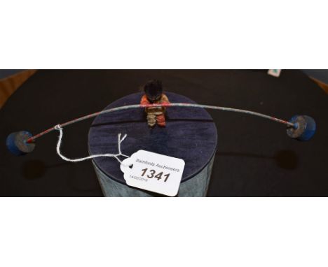 A late 19th/early 20th Century novelty cold painted lead and metal balance beam toy, centrally mounted with a wire and pipe c