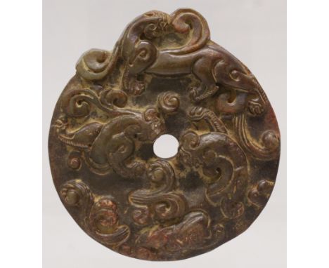 A CHINESE BROWN JADE-LIKE BI DISC, decorated in relief with chilong, 3.1in diameter.
