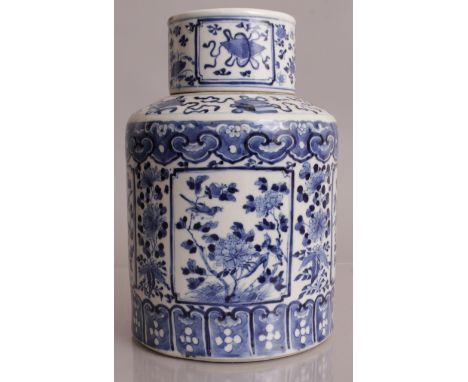 A 19TH CENTURY CHINESE CYLINDRICAL BLUE & WHITE TEA CADDY & COVER, the sides painted with square form panels of peony, the ba