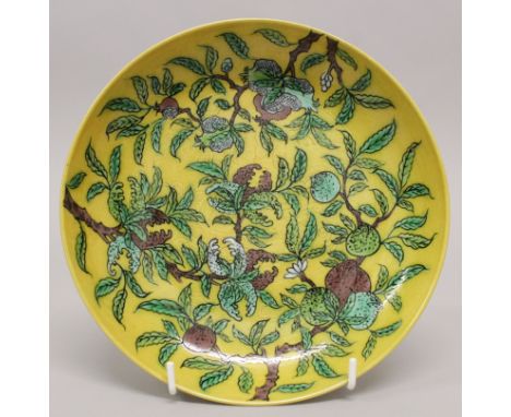 A CHINESE YELLOW GROUND PORCELAIN SAUCER DISH, decorated in green and aubergine with peach, pomegranate and finger citron, th