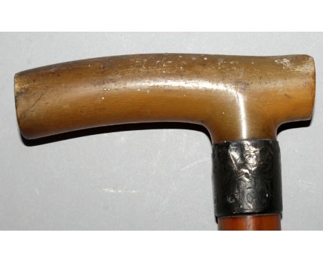 A 19TH CENTURY RHINO HORN HANDLED WOOD WALKING STICK, fitted with an English hallmarked silver collar, the yellowish-amber rh