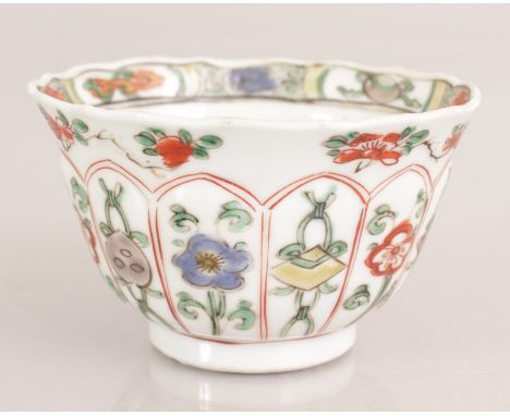 A CHINESE KANGXI PERIOD FAMILLE VERTE PORCELAIN TEABOWL, circa 1700, the sides painted with moulded lappet panels of ribboned