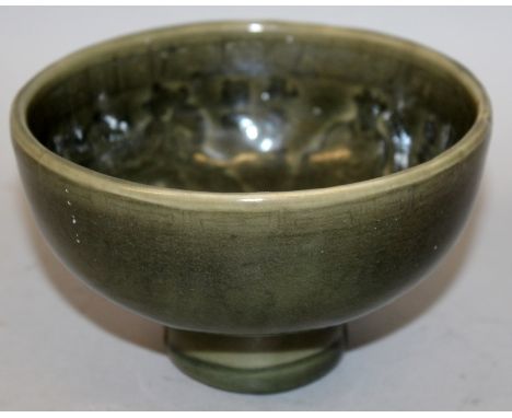 A CHINESE LONGQUAN STYLE CELADON CERAMIC BOWL, the interior moulded beneath the dark green glaze with figures of officials di