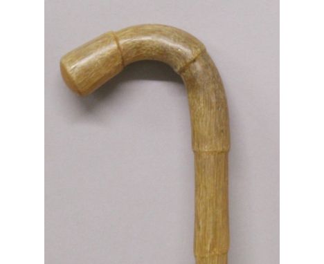 A GOOD EARLY 20TH CENTURY RHINO HORN TAPERING STICK, carved from a single piece and with a curved handle of bamboo form, the 