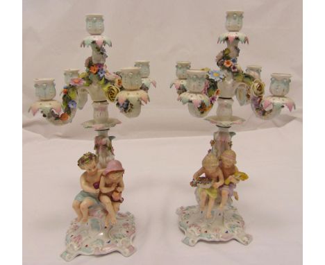 A pair of Sitzendorf five light candelabra the figural stems representing the four seasons and supporting scrolling arms encr