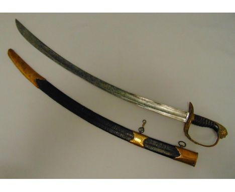 An early 19th century military officer dress sword in brass and leather scabbard with engraved blade, the carved wooden handl