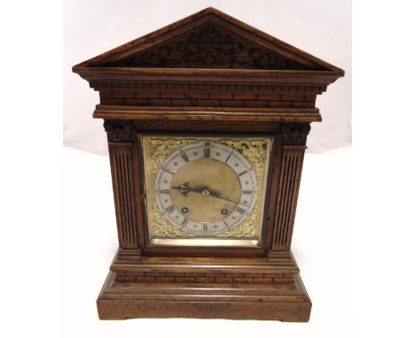 An oak cased mantle clock of architectural form, two train movement, silvered chapter ring with Roman numerals on raised rect