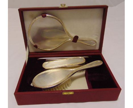 A Garrard hallmarked silver dressing table set with husk borders to include a hand mirror, a hair brush and comb in original 