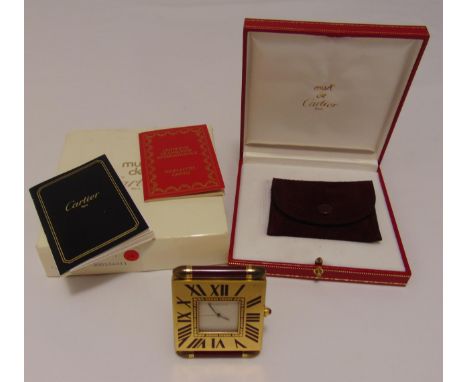 A Cartier quartz travel clock of square form with Roman numerals in original packaging and documents