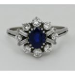 1 Damenring WG 18ct. zentral wohl 1 ovaler Saphir ca. 7,5x5,5mm, mit Diamanten im Brillant- und Bagu