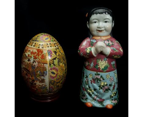 A Chinese porcelain figure of a standing sage with scroll; a figure of a child; and a pottery egg on stand, 45cm high max (3)