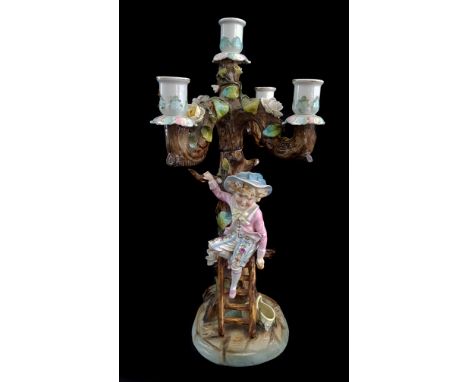 A German porcelain five light candelabra, modelled as a young boy climbing a ladder to pick apples from a tree, applied flore