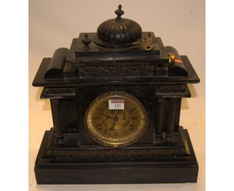 A late Victorian black slate mantel clock of architectural form having a gilded brass dial with Roman numerals and eight day 
