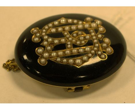 A late Victorian yellow metal, black onyx and seed pearl set mourning brooch, the obverse as a monogram (one seed pearl missi