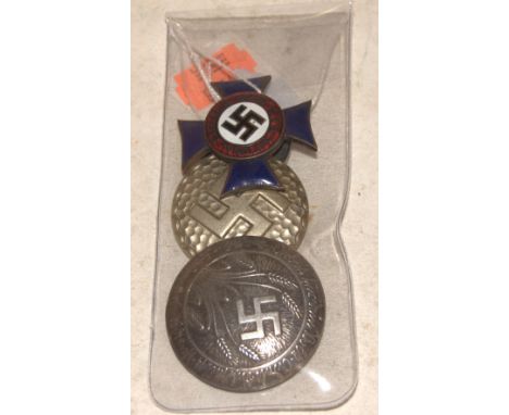 A reproduction NSDAP party enamel lapel badge together with two other German badges (3)