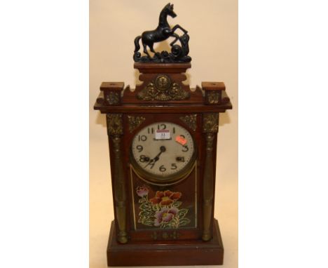 An early 20th century stained pine and glazed cased mantel clock, having enamelled dial with Arabic numerals and eight day mo