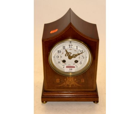 An Edwardian mahogany and satinwood inlaid cased mantel clock, of shaped rectangular form, having a painted enamel dial with 