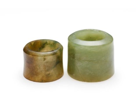 □ TWO CHINESE JADE ARCHERS RINGS, QING DYNASTY, 19TH CENTURY comprising: a small greyish-brown jade ring, 2cm high; and a cel