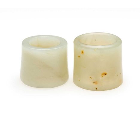 □ TWO CHINESE JADE ARCHERS RINGS, QING DYNASTY comprising of a celadon jade ring with tiny russet inclusions, 2.7cm high; and