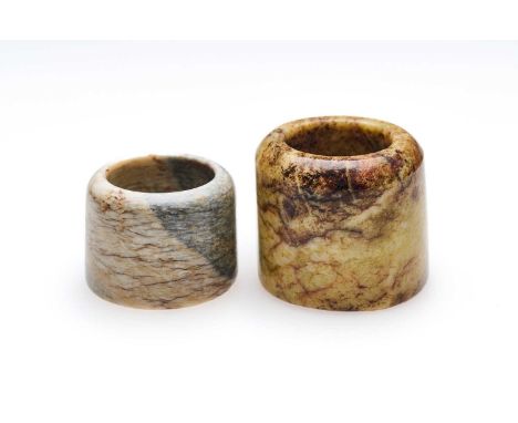 □ TWO CHINESE JADE ARCHERS RINGS, QING DYNASTY, 19TH CENTURY comprising: a yellowish jade ring with brown inclusions, 2.7cm h