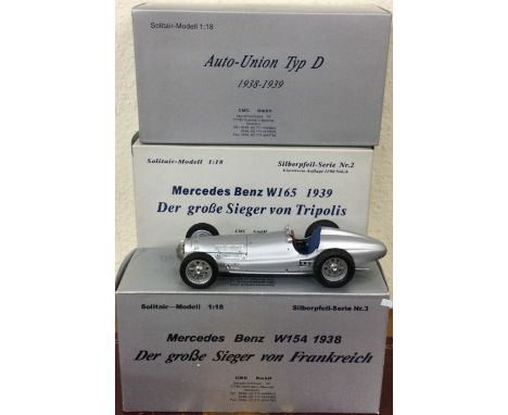 CMC: Three 1:18 scale boxed model racing cars. Est. £100 - £200.