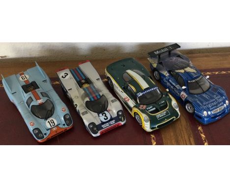 Four various 1:18 scale unboxed model racing cars. Est. £20 - £30.