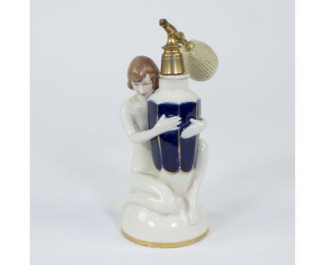 A Royal Dux art deco fine porcelain perfume bottle depicting a nude woman holding a faceted vase decorated with blue and gold